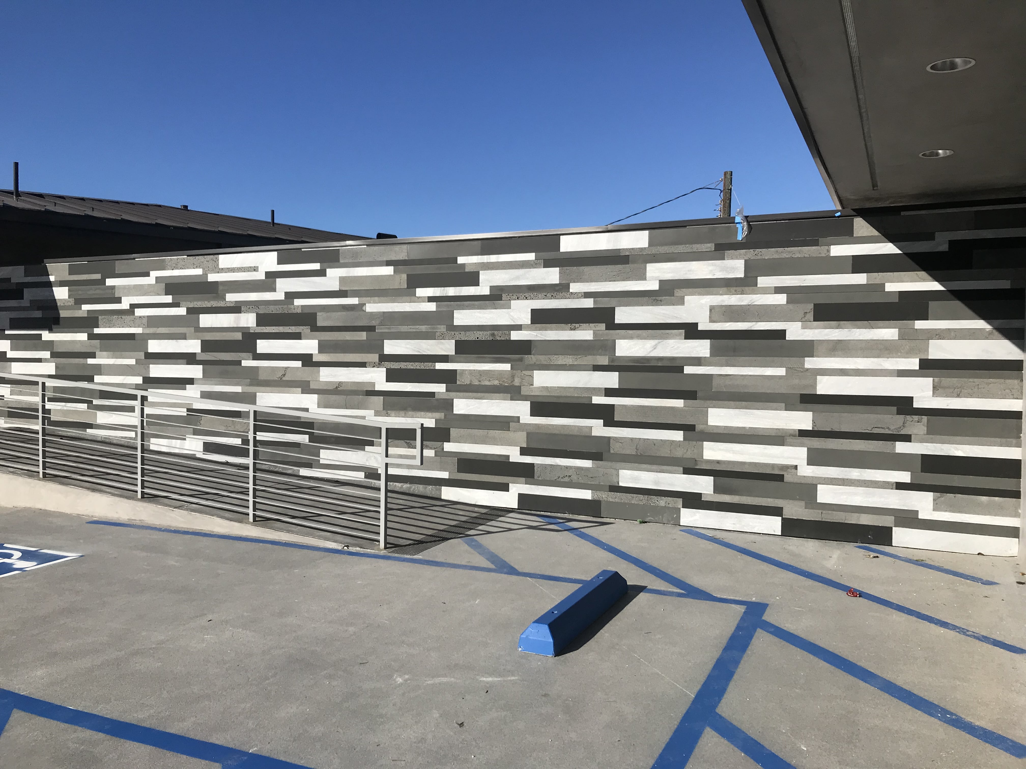 Exterior commercial wall clad in a mix of four colors of Norstone's Large Format Planc Tiles